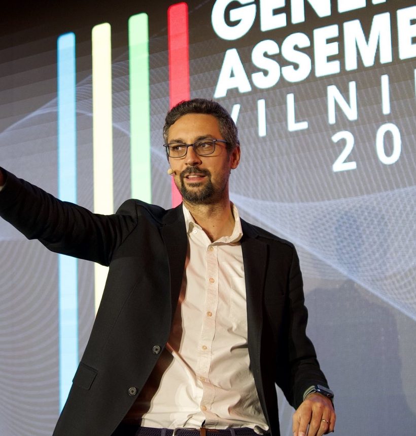 Nikola Ilic speaking on stage at a General Assembly in Vilnius, 2023